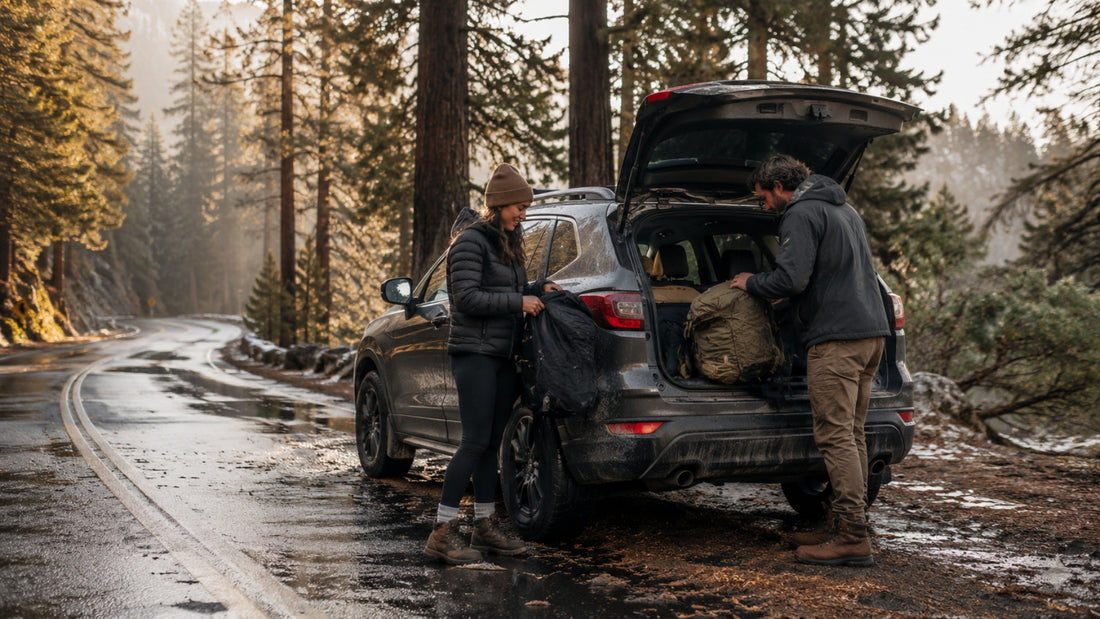 Two people loading a car with camping gear in a forest setting